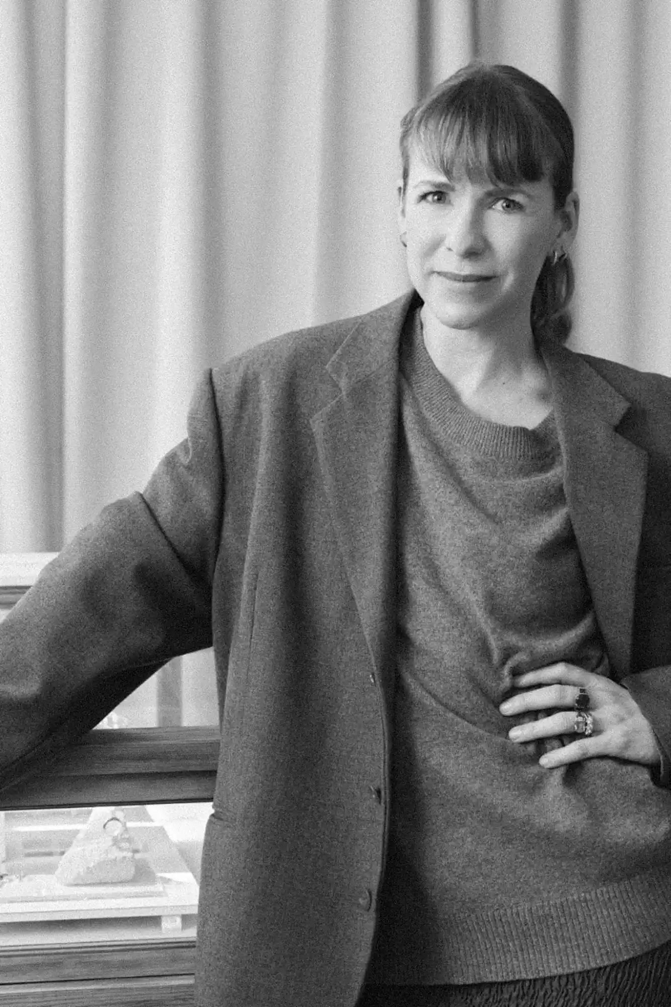 Black and white portrait of a woman in a blazer and sweater.