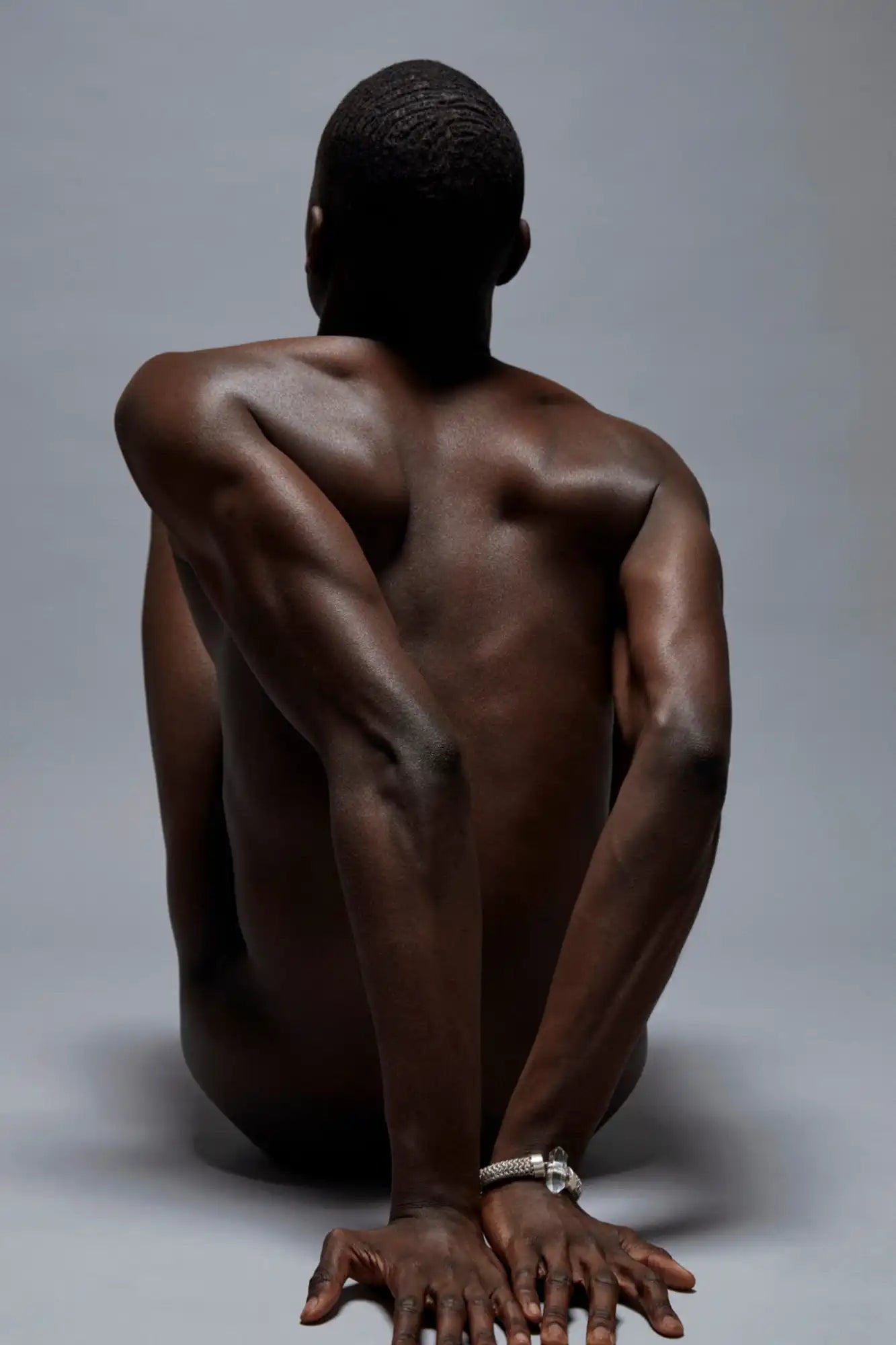 Dark-skinned man in yoga pose.