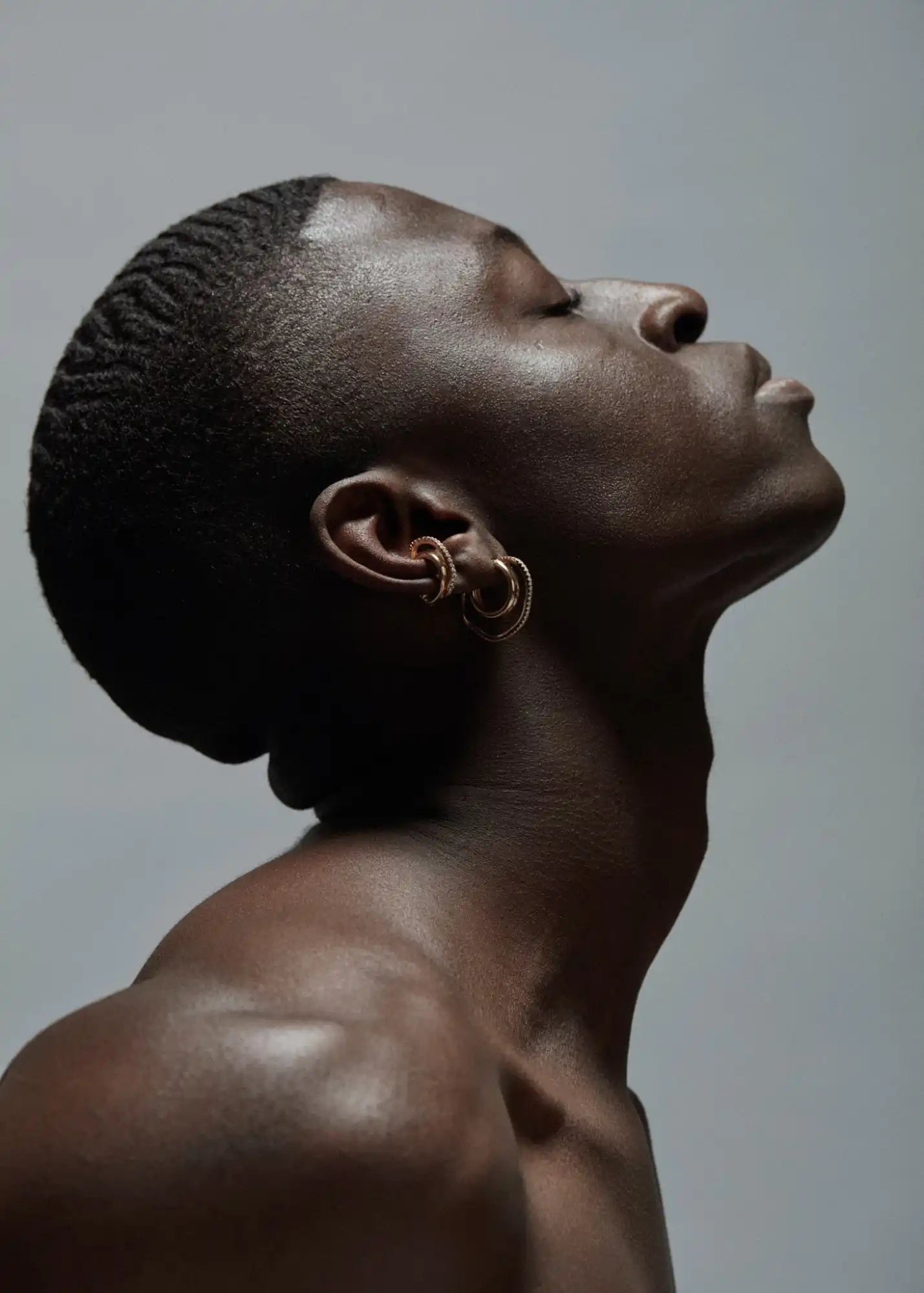 Dark-skinned person with gold earrings.