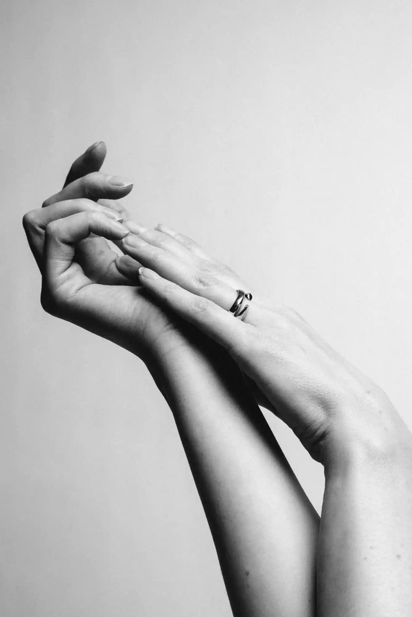 Intertwined hands with a ring.