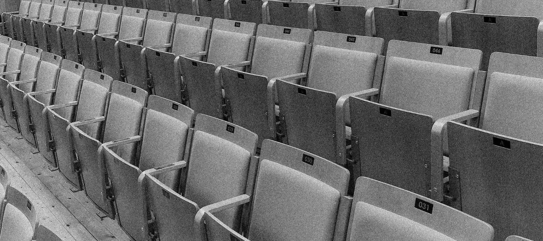 Rows of empty, upholstered theater seats.