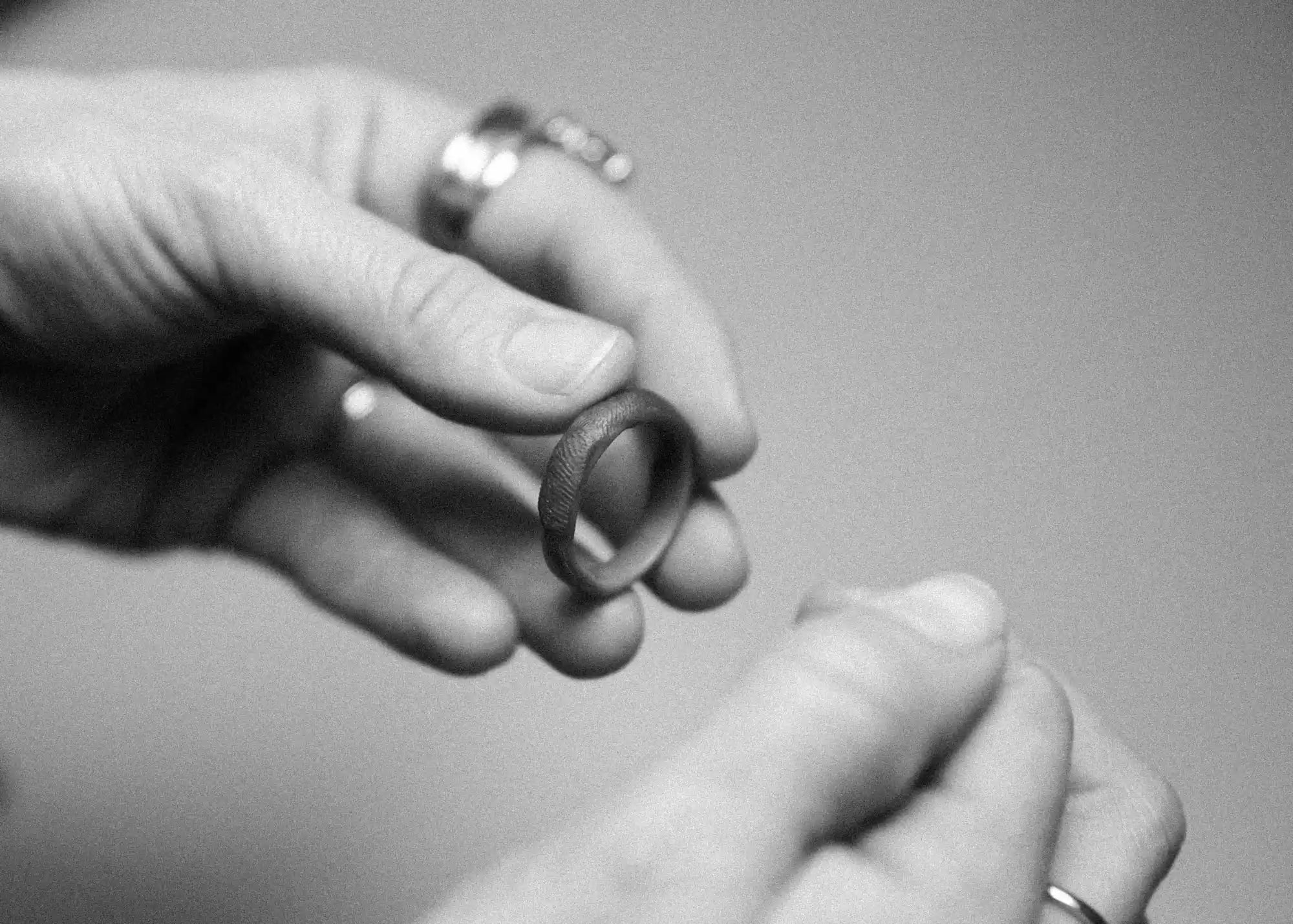 Textured ring held by hands.